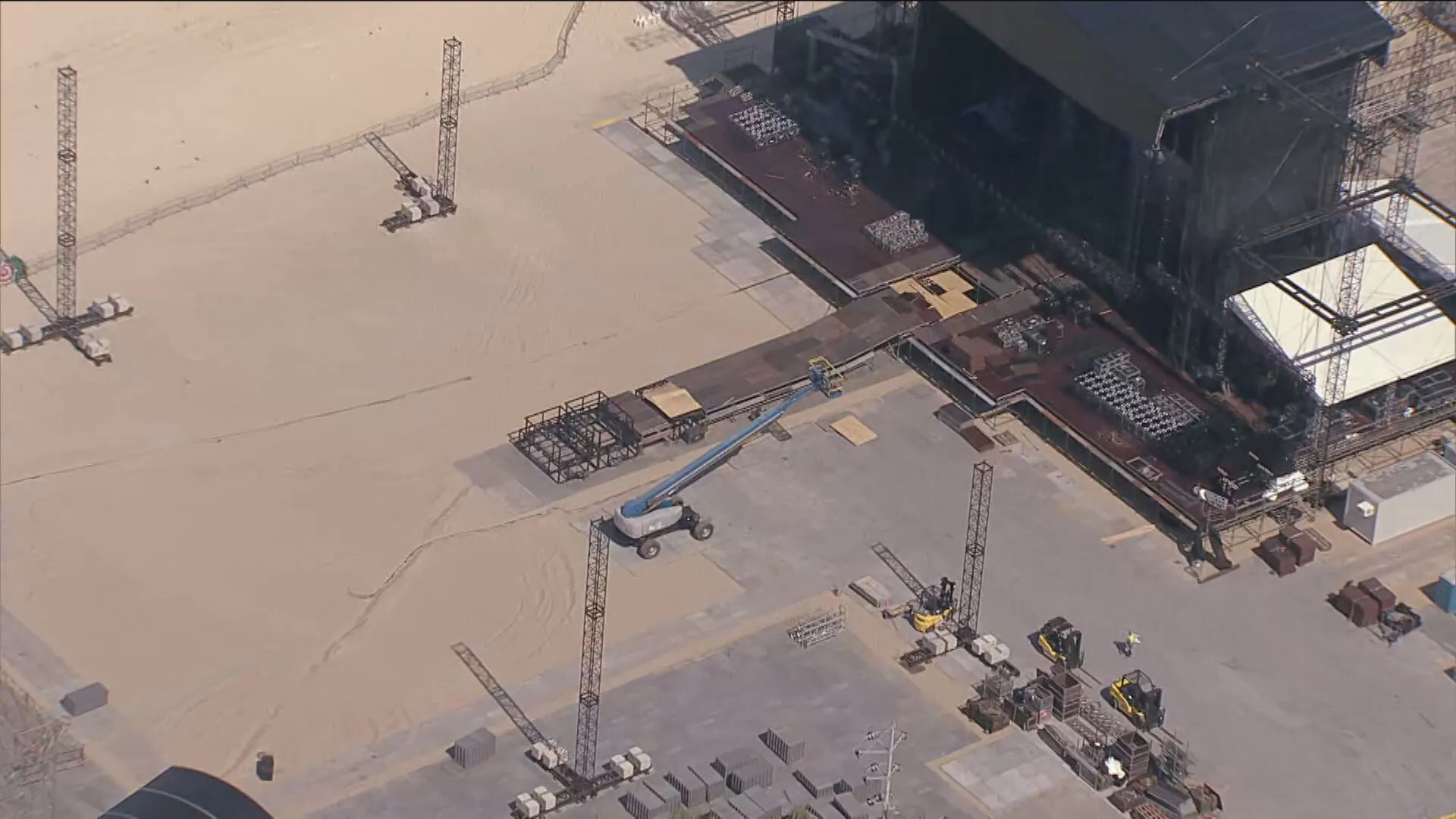 Palco do show da Shakira em Copacabana, ampliado e iluminado, com público na praia.