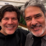 Paulo Ricardo cantando ao vivo, com luzes de palco ao fundo e microfone na mão.