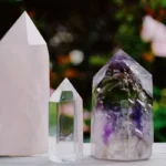 Diversas pedras e cristais coloridos e brilhantes, como ametista roxa e quartzo transparente, em exibição harmoniosa.