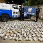 Policiais militares ao lado de grande apreensão de drogas em Petrópolis