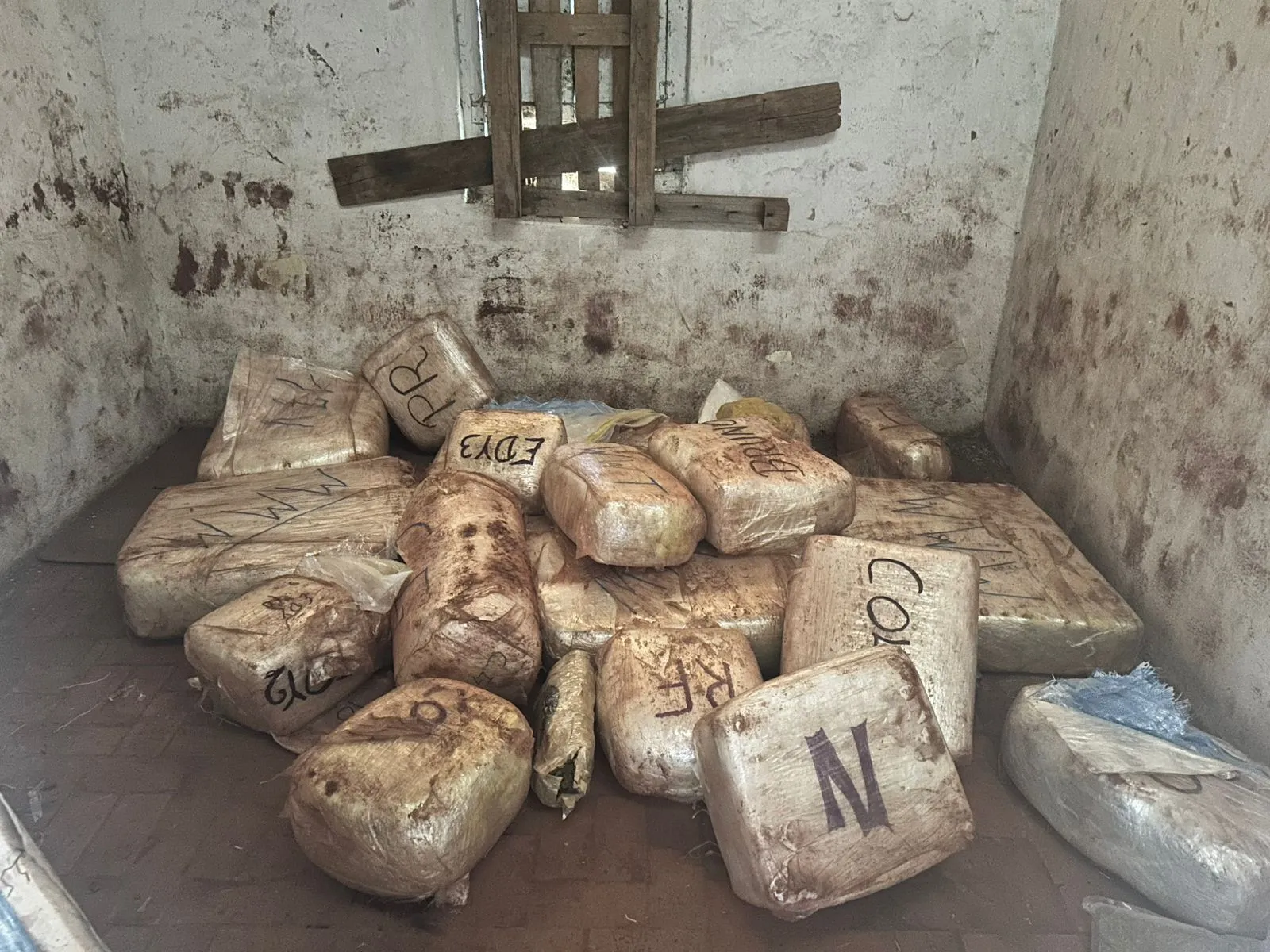 Mesa com drogas apreendidas, pistola 9mm, munições, caderno, balança, celulares e veículos em operação da Polícia Civil em Serra Negra.