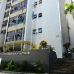 Distintivo policial e documento da Defensoria Pública simbolizando a denúncia contra policiais civis no Rio de Janeiro.