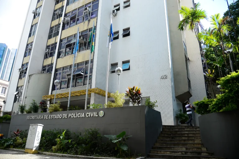 Distintivo policial e documento da Defensoria Pública simbolizando a denúncia contra policiais civis no Rio de Janeiro.