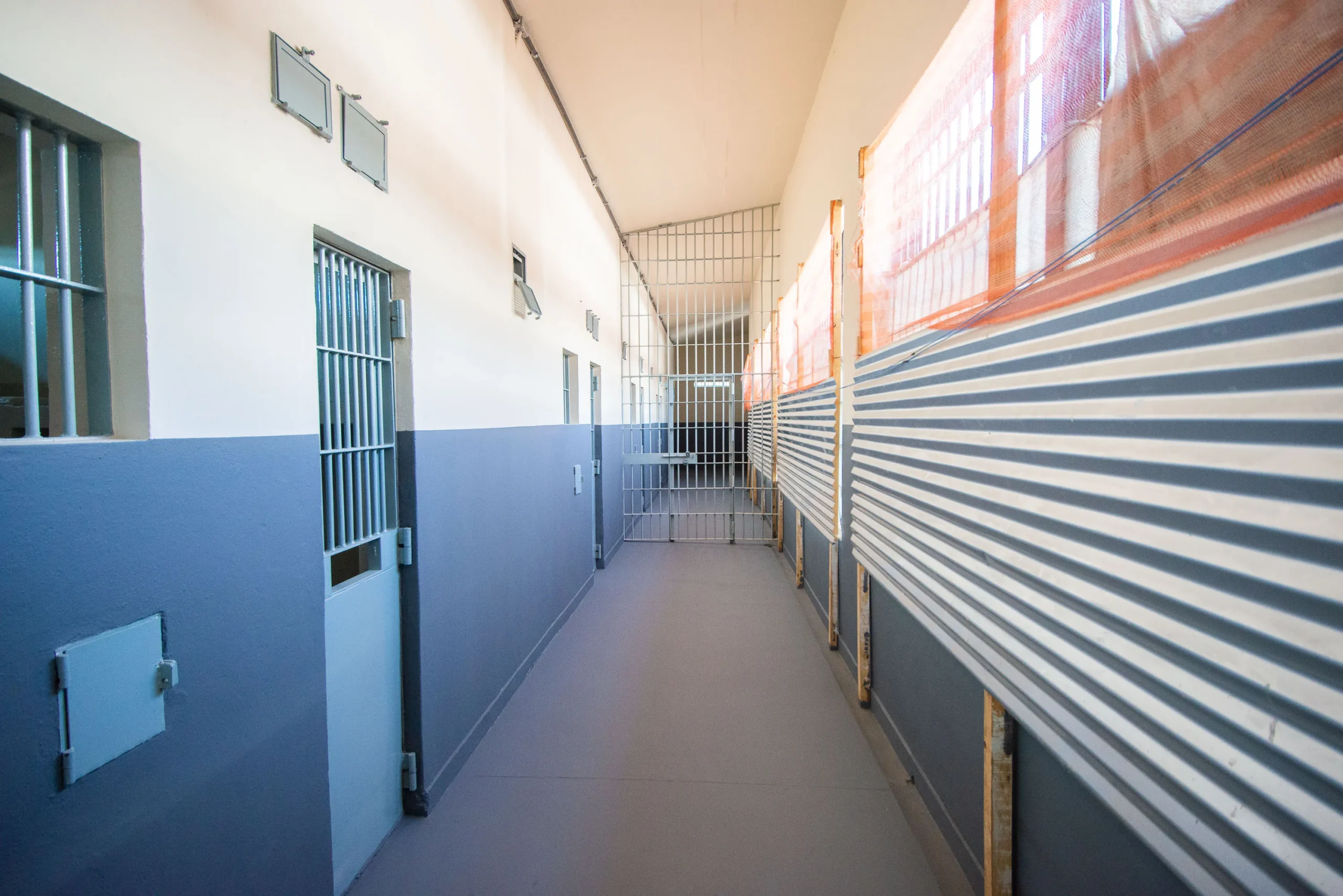 Foto do Presídio de Vespasiano ao entardecer, com muros altos e guarita, simbolizando a segurança.