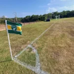 Quatro equipes de futebol em campo, aguardando o início das semifinais do festival Polo Oeste no Pará, com o CT Boto da Amazônia ao fundo.