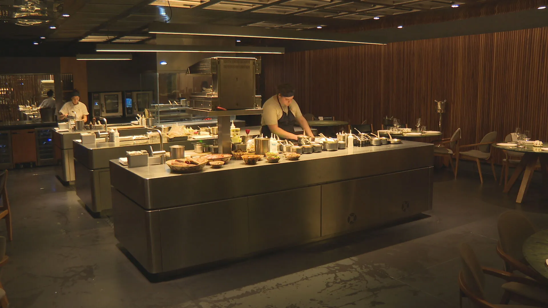 Salão de jantar elegante do restaurante Tuju, com mesas bem arrumadas e iluminação ambiente, refletindo a sofisticação de um restaurante com três estrelas Michelin.