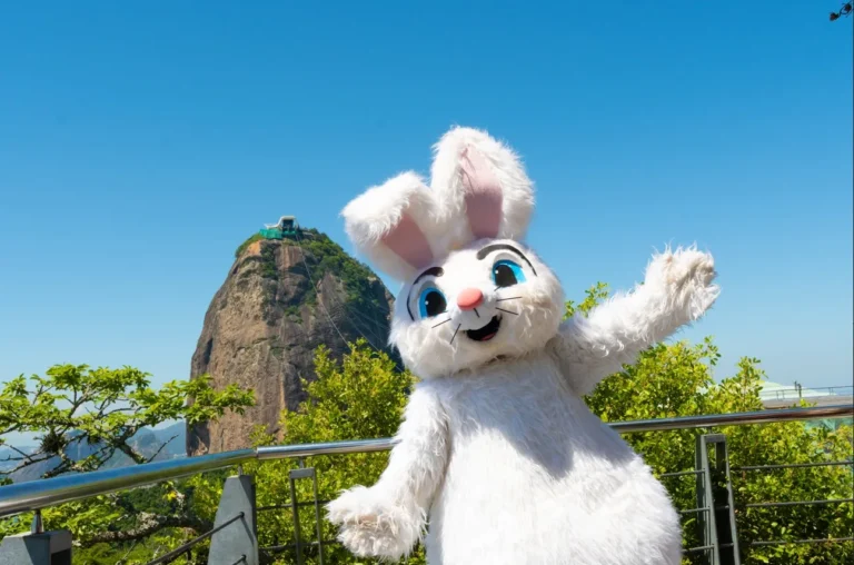 Crianças brincando de caça aos ovos de Páscoa em um jardim florido, com um coelho de pelúcia.