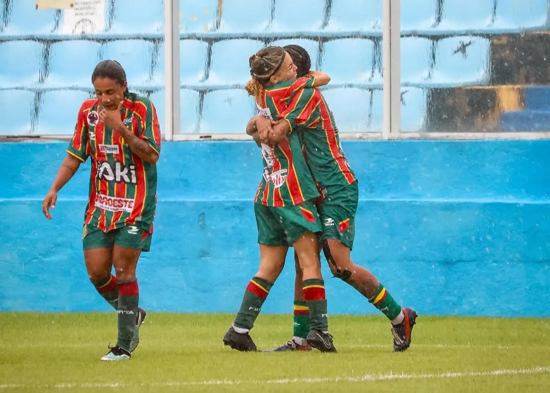 Jogadoras da Copa do Brasil Feminina em campo, com uniforme vermelho e azul, disputando a bola.