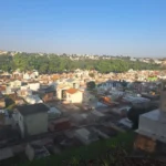 Pessoa limpando sepultura no cemitério de Presidente Prudente antes do Dia das Mães