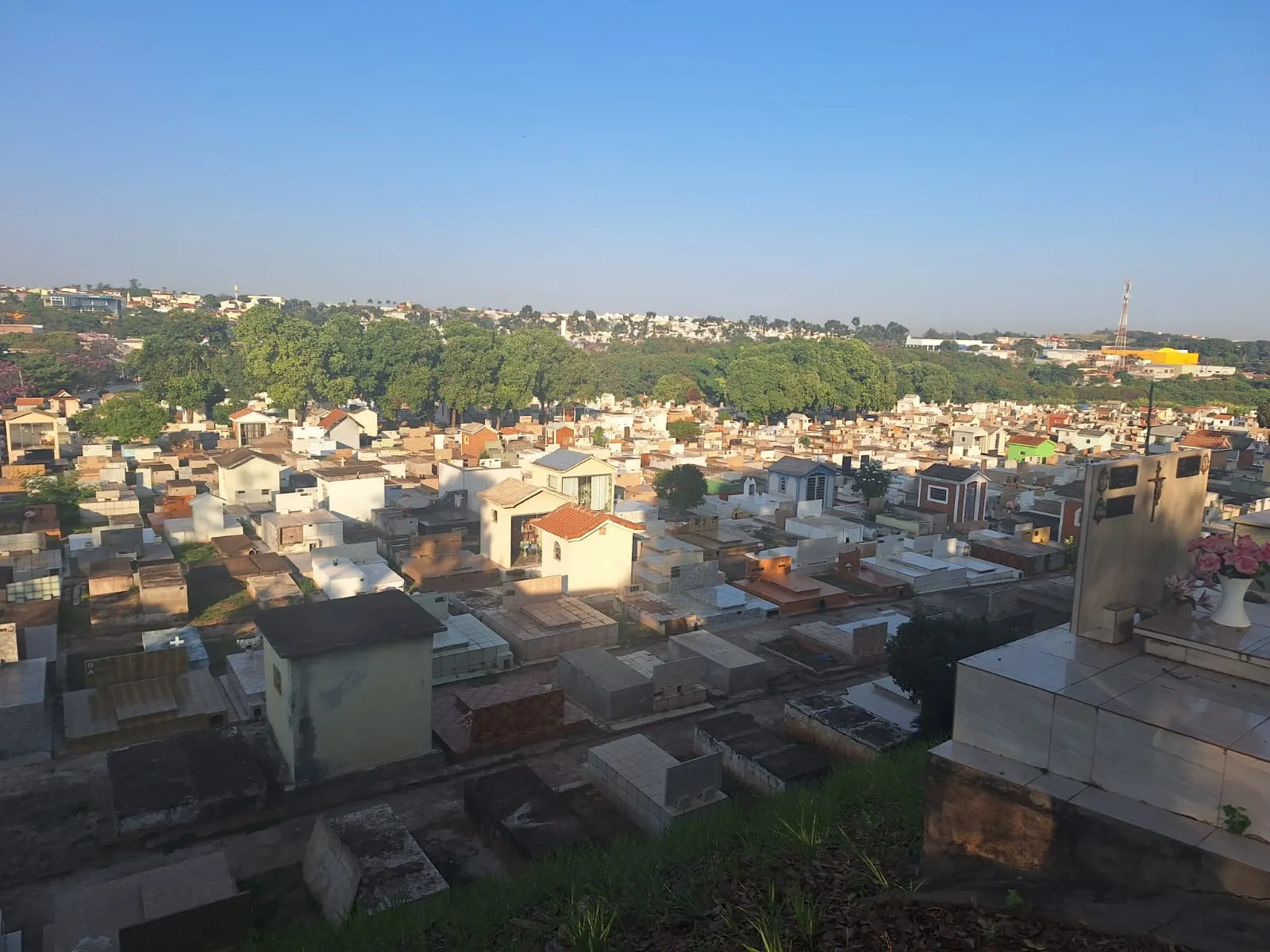 Pessoa limpando sepultura no cemitério de Presidente Prudente antes do Dia das Mães
