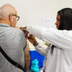 Grupo diverso sendo vacinado contra gripe em Petrópolis, reforçando a proteção coletiva.