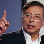 Presidente Gustavo Petro falando em um evento, com o logo do Pix ao fundo, ilustrando a defesa do sistema de pagamentos instantâneos.