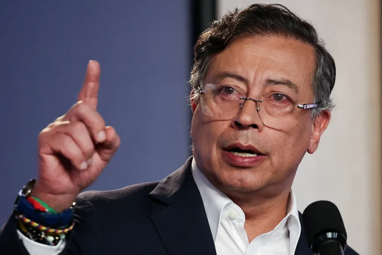Presidente Gustavo Petro falando em um evento, com o logo do Pix ao fundo, ilustrando a defesa do sistema de pagamentos instantâneos.