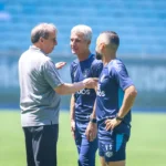 Presidente Odorico Roman ao lado do técnico Luís Castro, ambos com expressão de seriedade e foco, em um evento oficial do Grêmio.