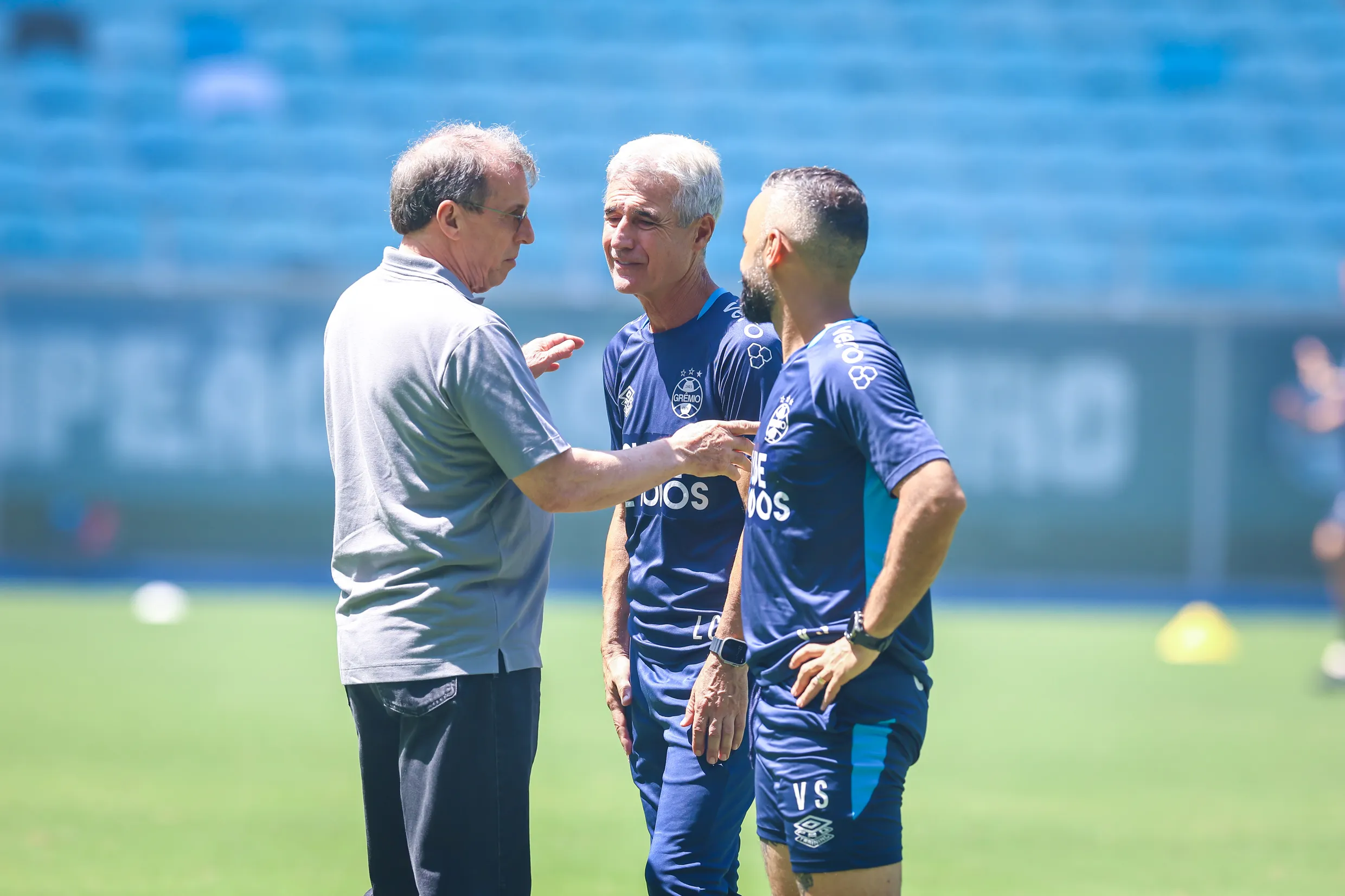 Presidente Odorico Roman ao lado do técnico Luís Castro, ambos com expressão de seriedade e foco, em um evento oficial do Grêmio.