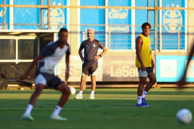 Luís Castro, técnico do Grêmio, em campo, com expressão séria e concentrada, refletindo a pressão por resultados e a situação atual do time.