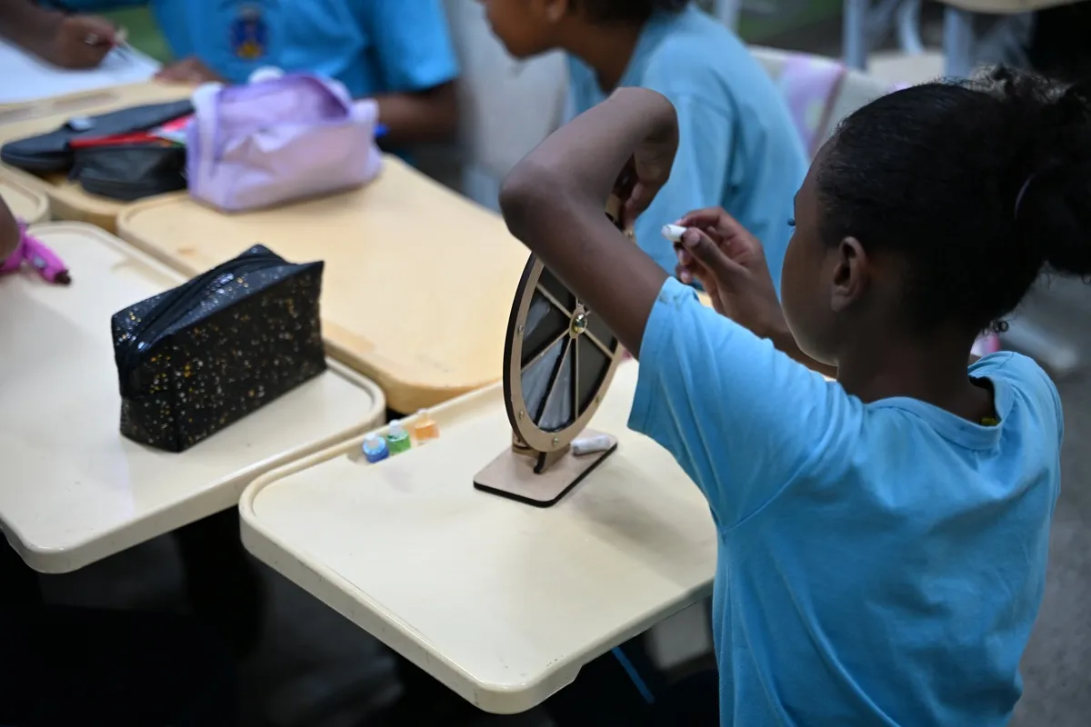 Grupo de estudantes colaborando em aula prática tecnológica em Petrópolis, com foco em sustentabilidade e games.