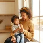 Mulher jovem e reflexiva em casa, pensando sobre a ausência do pai e seus efeitos.