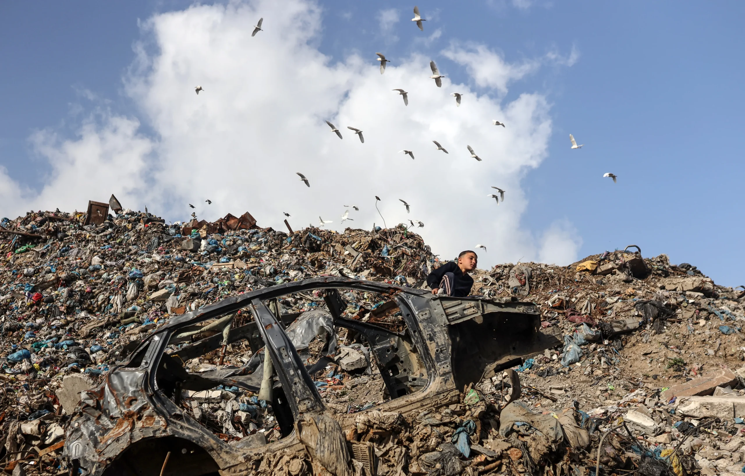 Menino palestino em lixão, crise humanitária Gaza, Mercado Firas, reciclagem informal, impactos da guerra, lixo em Gaza
