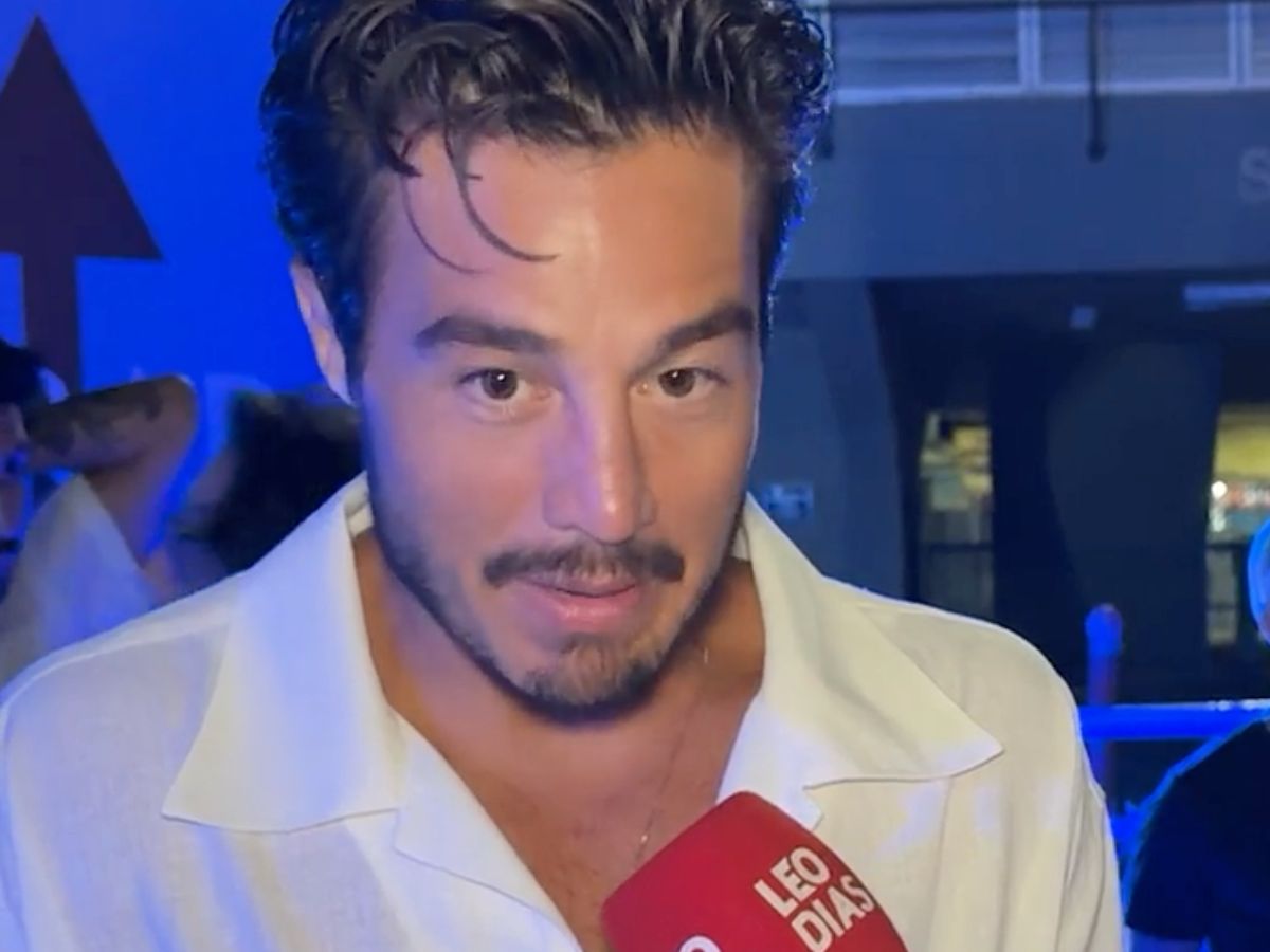 Tiago Iorc e Duda Santos conversando em um ambiente social com roupas elegantes