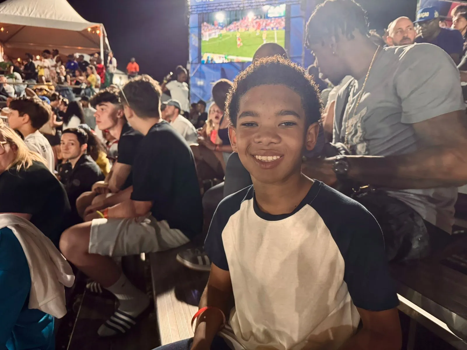 Ronaldinho Gaúcho em campo na Legends Cup em Curaçao, cercado por fãs e comemorações.