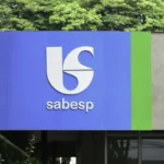 Pessoa com expressão de raiva segurando conta da Sabesp no Procon