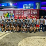 Jogadores do Santa Cruz-AC desembarcando do ônibus em Porto Velho, com uniformes de viagem, prontos para o amistoso contra a Seleção Sub-15.