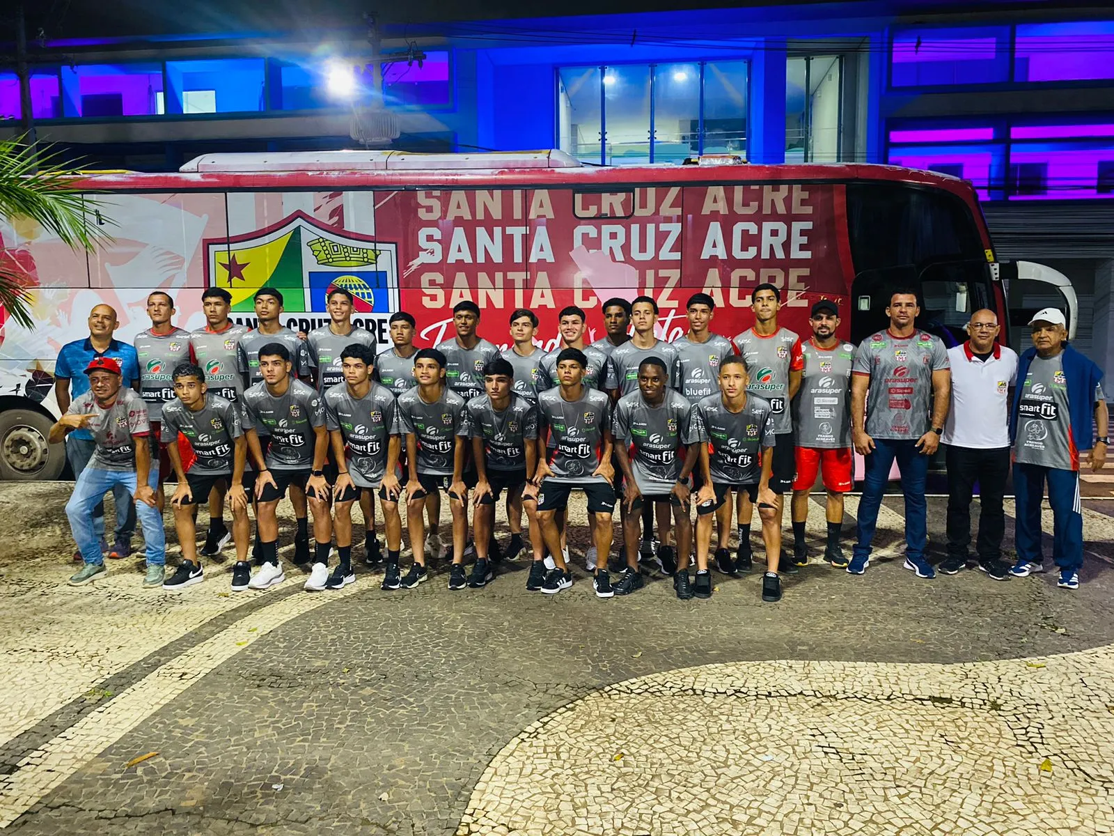 Jogadores do Santa Cruz-AC desembarcando do ônibus em Porto Velho, com uniformes de viagem, prontos para o amistoso contra a Seleção Sub-15.
