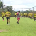 Time de futebol Santa Cruz-AC Sub-15 treinando em campo de grama verde