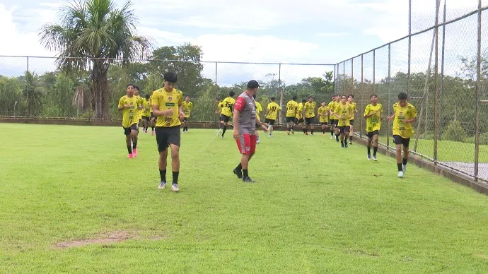 Time de futebol Santa Cruz-AC Sub-15 treinando em campo de grama verde