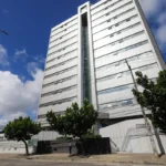 Prédio da Jucepe em Recife, Pernambuco, com pessoas passando, simbolizando as vagas de emprego abertas.