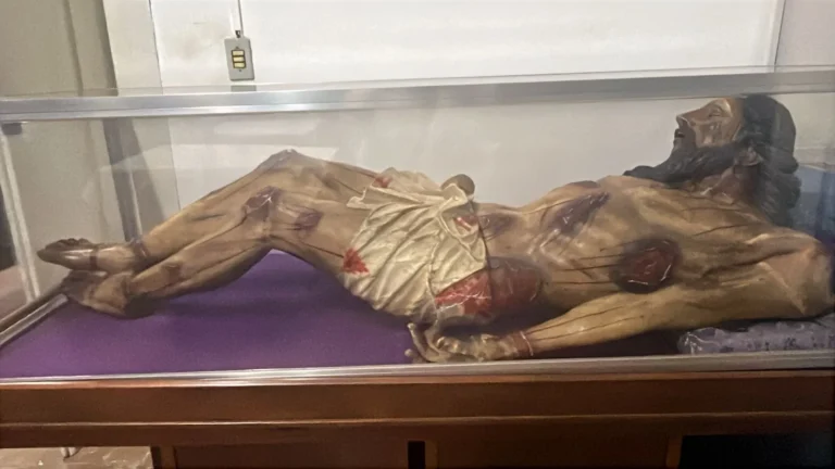 Procissão noturna da Semana Santa com fiéis e imagem religiosa em cidade histórica