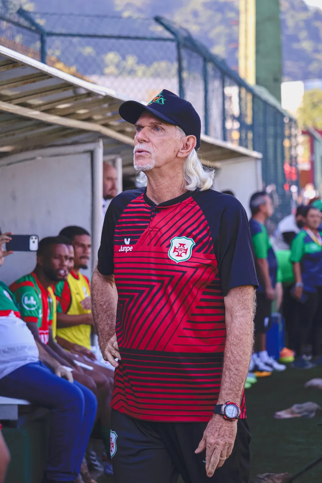 Time da Portuguesa Santista comemora o acesso à Série A2 do Campeonato Paulista, com o técnico Sérgio Guedes e jogadores abraçados em campo.