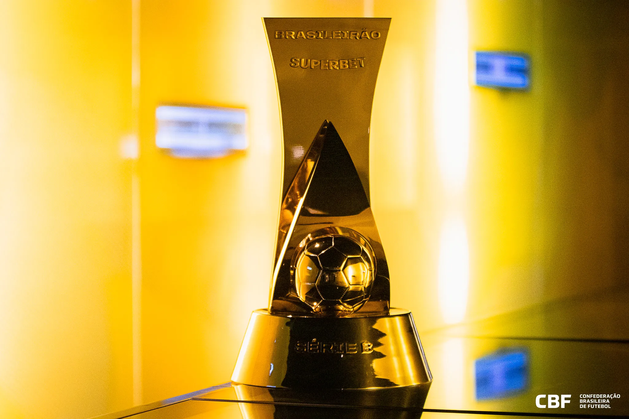 Estádio de futebol com jogo da Série B 2026 em andamento, torcedores assistindo, campo verde