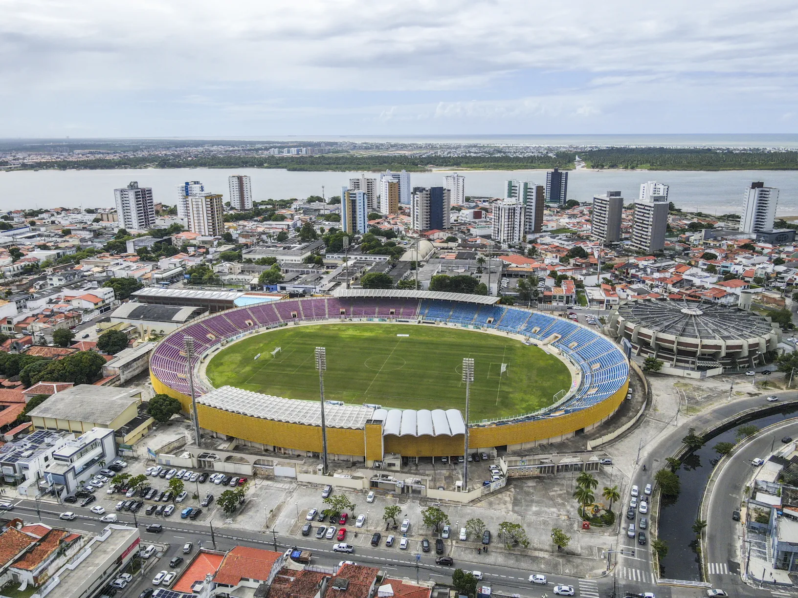 Vista aérea da Arena Batistão em Aracaju, Sergipe, com o campo de futebol e arquibancadas, iluminada pela luz do fim de tarde, antes do jogo Sergipe e Lagarto pela Série D.