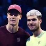 Jannik Sinner e Carlos Alcaraz, tenistas, cumprimentando-se em quadra, com Alcaraz lesionado