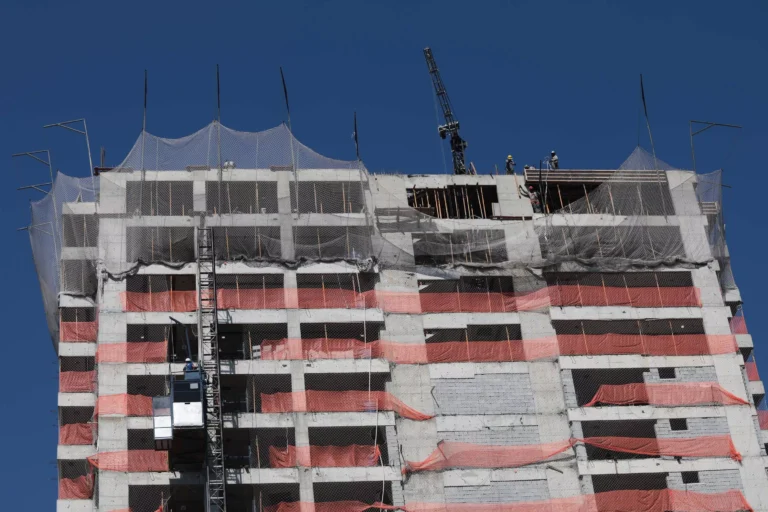 Skyline de São Paulo com prédios em construção e guindastes, representando o avanço das novas obras na capital.