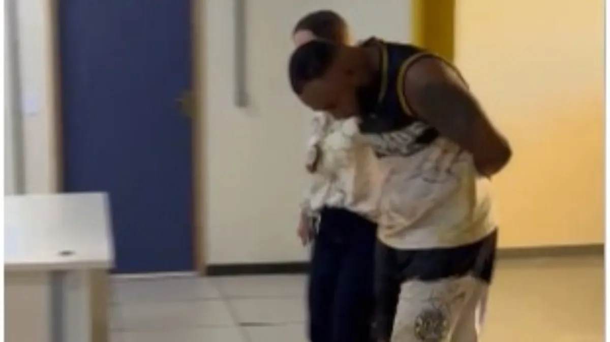 Marlon Oliveira da Silva, suspeito de milícia, algemado e escoltado por policiais no Rio de Janeiro.