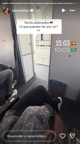 Influenciadora Tainá Militão sorrindo durante coleta de sangue para sexagem fetal em sua casa, com profissional de saúde.