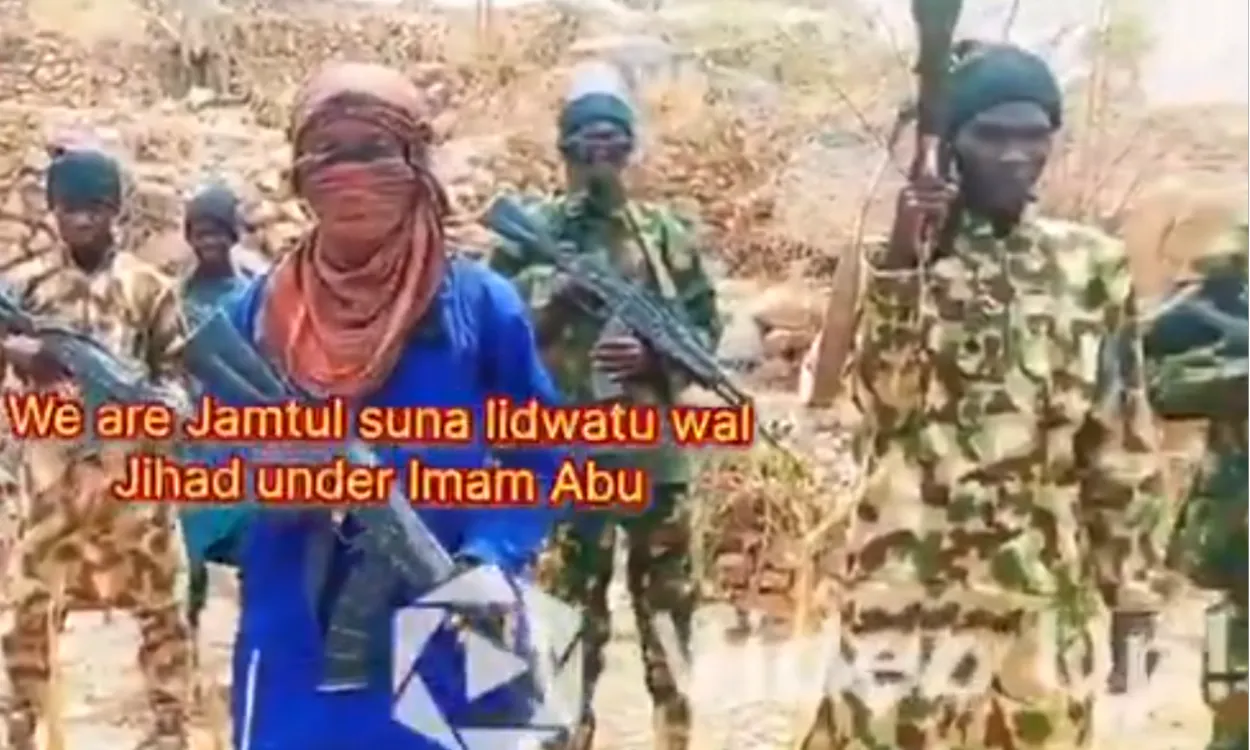 Membros do grupo Boko Haram armados em cenário da Nigéria, ameaçando reféns por resgate de R$ 18,5 milhões.