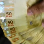 Moedas empilhadas simbolizando a carga tributária brasileira de 32,4% do PIB
