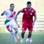 Time do Tombense jogando bola em partida noturna da Série D