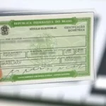 Pessoas em fila para atendimento no mutirão eleitoral do TRE-MG, em escola de Belo Horizonte.