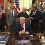 Navio-tanque gigante navegando pelo Estreito de Ormuz, com montanhas áridas ao fundo