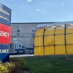 Tenda de descontaminação e ambulâncias em frente ao hospital após vazamento químico em fábrica.