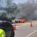 Carro em chamas na Rodovia Oswaldo Cruz, Ubatuba, com trânsito parado e equipes de resgate.
