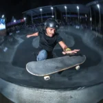Vini Sardi em cadeira de rodas realizando manobra de skate em pista de street, Florianópolis