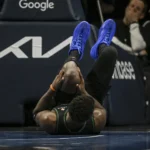 Jogadores dos Wolves e Nuggets em quadra durante um jogo de playoffs da NBA, com um atleta do Timberwolves comemorando ou em ação.