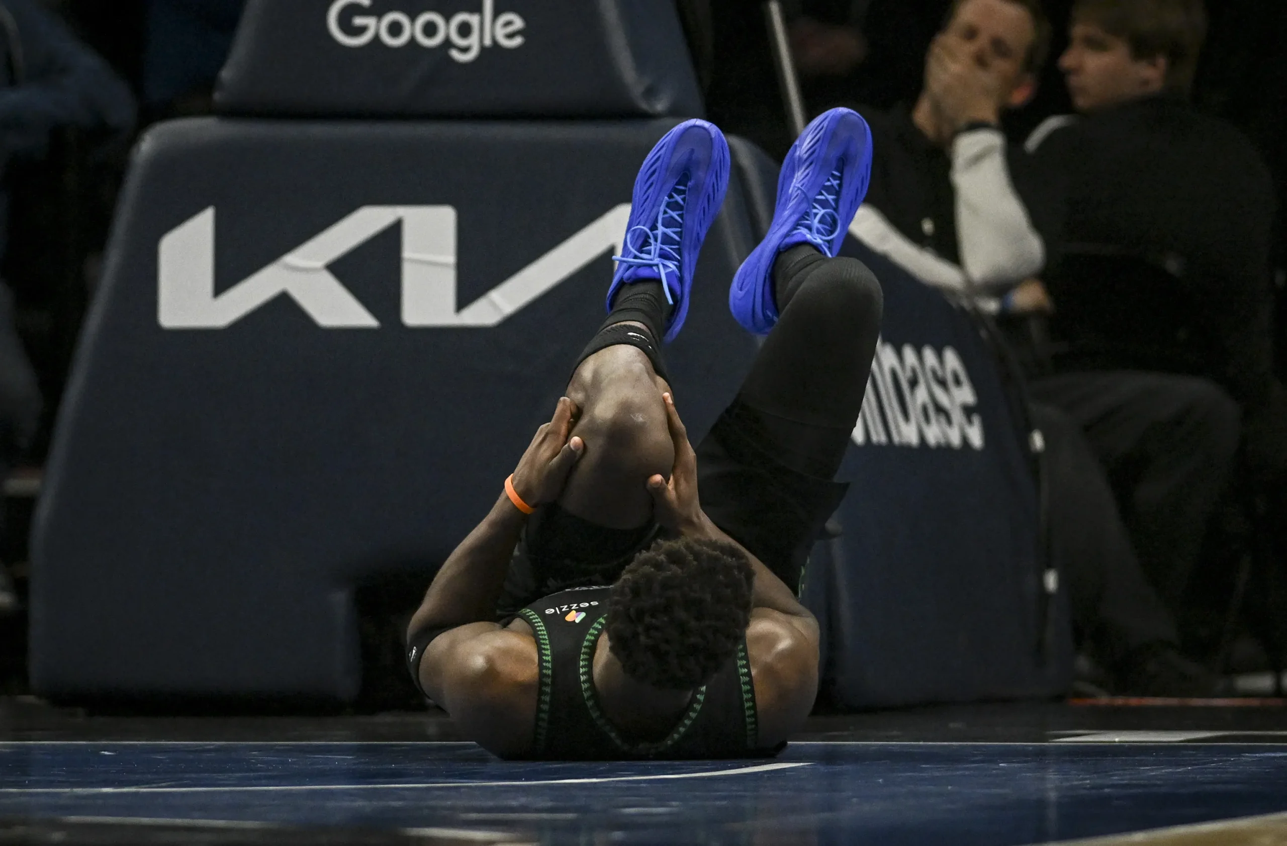 Jogadores dos Wolves e Nuggets em quadra durante um jogo de playoffs da NBA, com um atleta do Timberwolves comemorando ou em ação.